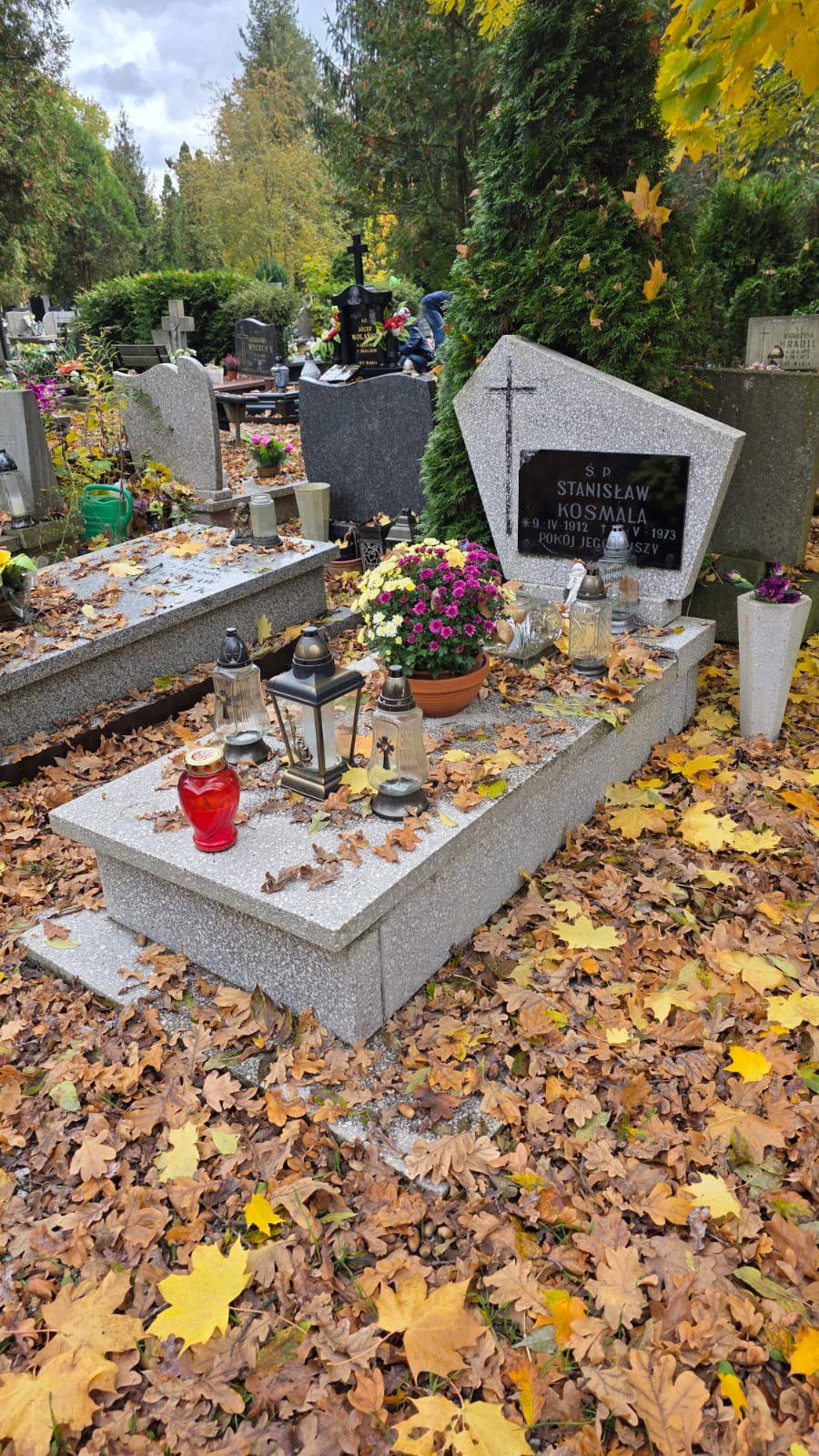 Nagrobek przed sprzątaniem — liście i zabrudzone otoczenie